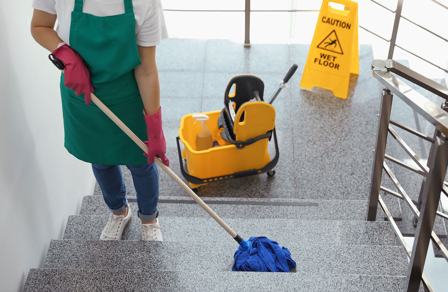 Eine Person wischt eine Treppe mit einem Mopp